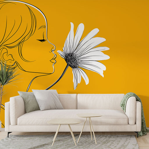 Un salon moderne avec un papier peint jaune vif représentant le profil d'une jeune fille et une grande fleur en noir, créant une ambiance joyeuse et artistique.