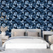 Une chambre moderne avec un papier peint floral bleu nuit aux motifs délicats de fleurs et de feuilles, créant une ambiance apaisante et élégante.