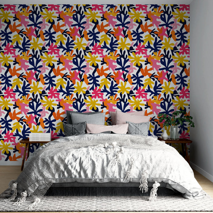 Une chambre moderne avec un papier peint coloré aux motifs floraux dynamiques, mêlant des teintes vives de rose, jaune et bleu marine, créant une ambiance joyeuse et énergisante.