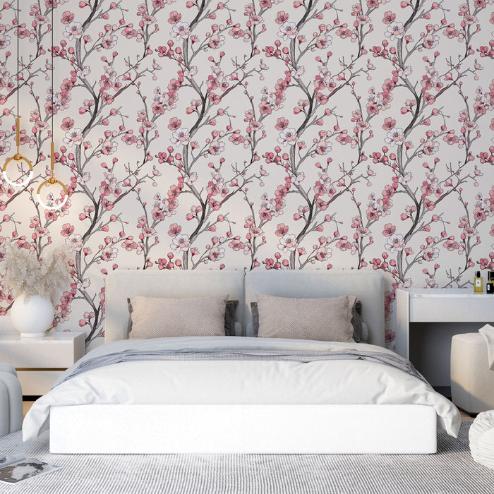 Une chambre élégante avec un papier peint floral aux motifs de branches fleuries roses sur fond clair, créant une atmosphère douce et apaisante.