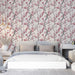 Une chambre élégante avec un papier peint floral aux motifs de branches fleuries roses sur fond clair, créant une atmosphère douce et apaisante.