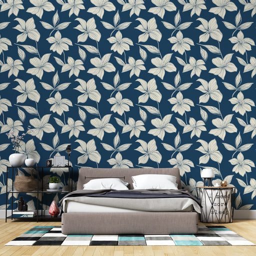 Une chambre moderne avec un papier peint floral bleu marine et crème, offrant une ambiance élégante et apaisante grâce à ses motifs délicats.