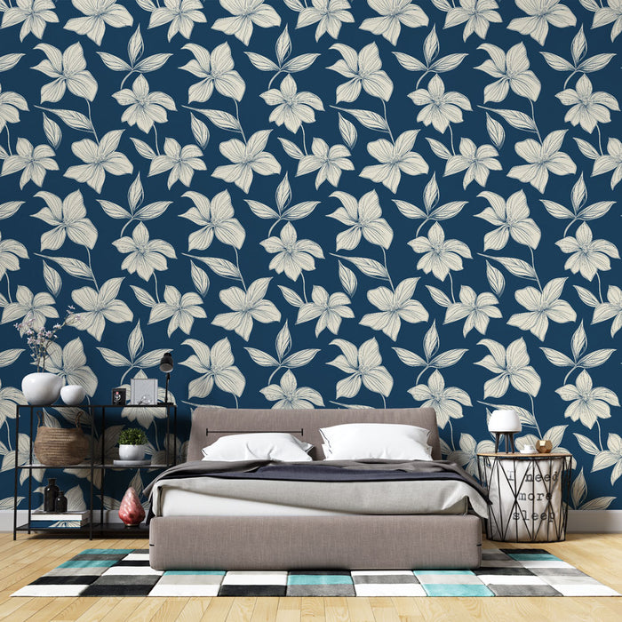 Une chambre moderne avec un papier peint floral bleu marine et crème, offrant une ambiance élégante et apaisante grâce à ses motifs délicats.