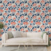 Un salon lumineux avec un papier peint floral représentant des tulipes corail et des feuillages bleu marine, créant une atmosphère chaleureuse et accueillante.