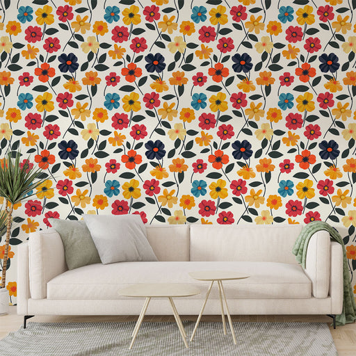 Un salon lumineux avec un papier peint floral aux motifs colorés de fleurs rouges, jaunes et bleues sur fond crème, créant une ambiance joyeuse et accueillante.