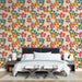 Une chambre moderne avec un papier peint floral aux motifs colorés de fleurs rouges, oranges et vertes sur fond beige, créant une ambiance joyeuse et vivante.
