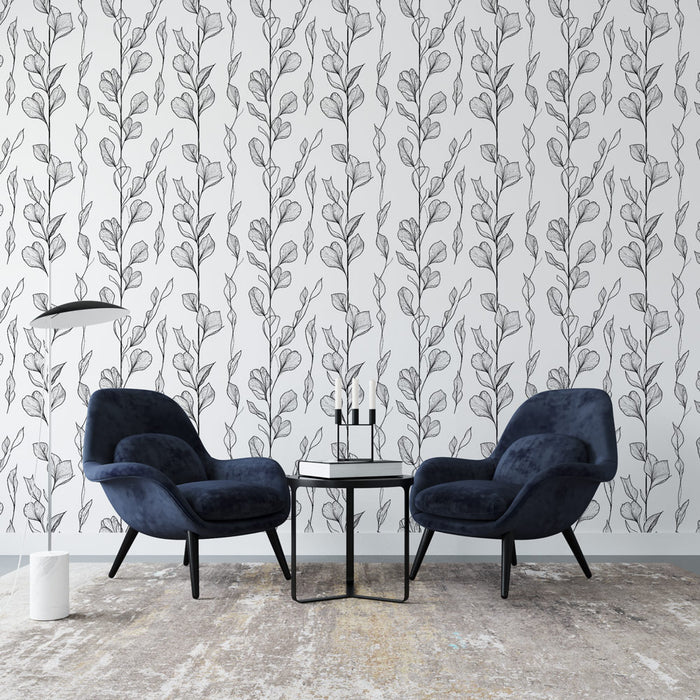 Un salon moderne avec un papier peint aux motifs de feuilles délicates en noir sur fond blanc, créant une ambiance élégante et apaisante.