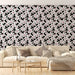 Un salon lumineux avec un papier peint floral noir et blanc, orné de fleurs délicates et de touches de rose, créant une ambiance dynamique et élégante.