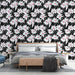 Une chambre moderne avec un papier peint floral noir et blanc, agrémenté de touches roses, créant une ambiance à la fois élégante et vivifiante.