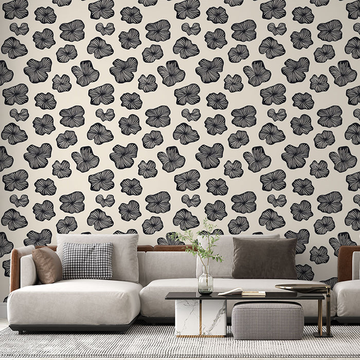 Un salon moderne avec un papier peint floral noir sur fond crème, créant une ambiance élégante et artistique.