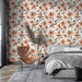 Une chambre moderne avec un papier peint floral aux motifs orange et noirs sur fond clair, créant une ambiance chaleureuse et accueillante.