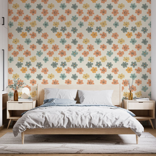 Une chambre lumineuse avec un papier peint floral aux motifs colorés de fleurs orange, jaunes et vertes sur fond clair, créant une atmosphère joyeuse et accueillante.