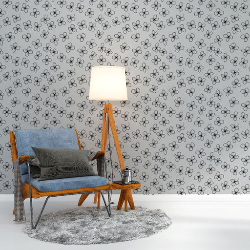 Une pièce cosy avec un papier peint floral noir et blanc sur fond gris, créant une atmosphère douce et apaisante.