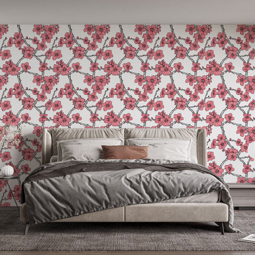 Une chambre élégante avec un papier peint floral aux motifs de fleurs roses sur fond blanc, créant une atmosphère douce et romantique.