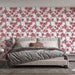 Une chambre élégante avec un papier peint floral aux motifs de fleurs roses sur fond blanc, créant une atmosphère douce et romantique.