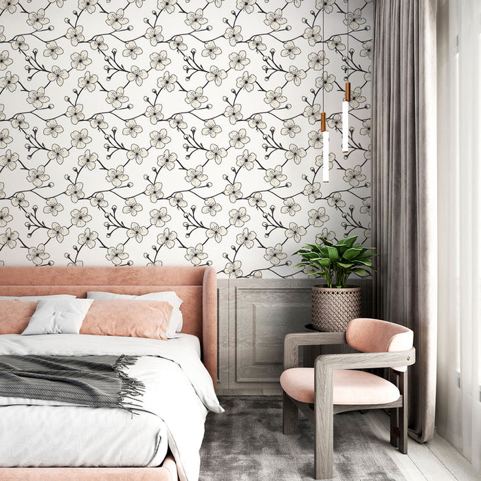 Une chambre élégante avec un papier peint floral noir et blanc représentant des fleurs délicates, créant une ambiance douce et apaisante.