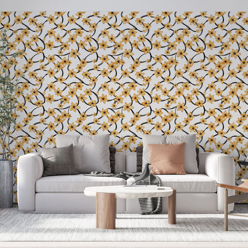 Un salon moderne avec un papier peint floral aux motifs jaunes et noirs sur fond blanc, créant une atmosphère lumineuse et accueillante.