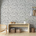 Une entrée lumineuse avec un papier peint floral beige et noir, aux motifs délicats de petites fleurs, créant une ambiance douce et accueillante.