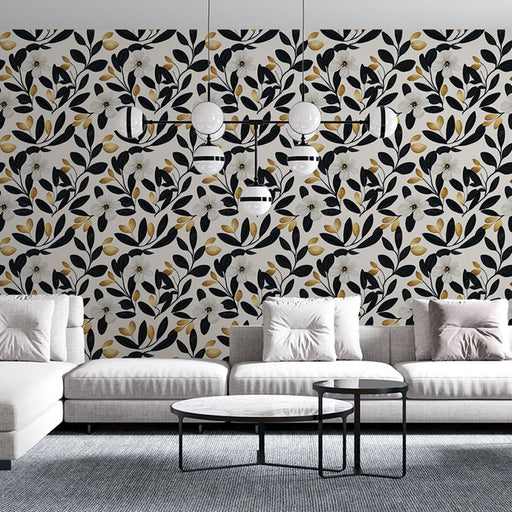 Un salon contemporain avec un papier peint floral noir et doré sur fond clair, créant une atmosphère élégante et chaleureuse.