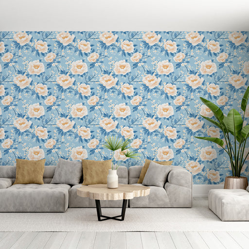 Un salon lumineux avec un papier peint floral bleu clair orné de grandes fleurs roses et de branches délicates, créant une atmosphère douce et apaisante.