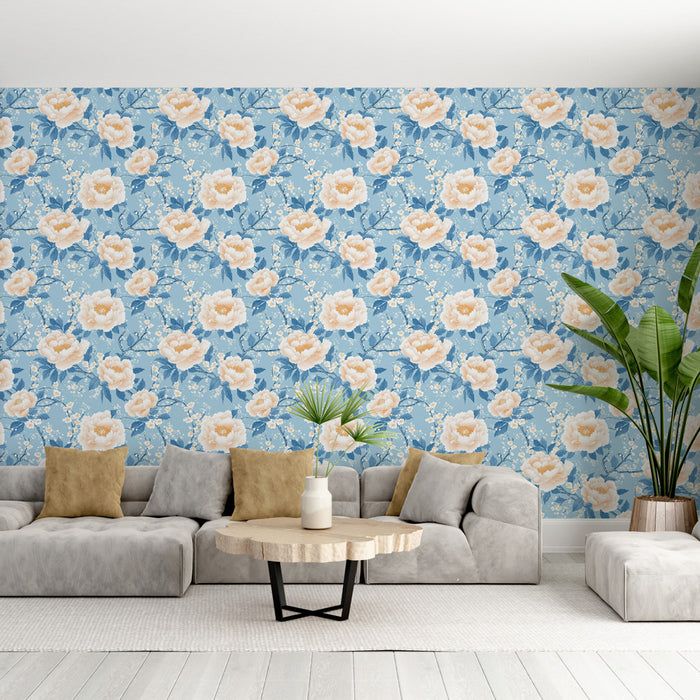 Un salon lumineux avec un papier peint floral bleu clair orné de grandes fleurs roses et de branches délicates, créant une atmosphère douce et apaisante.