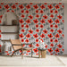 Une pièce lumineuse avec un papier peint floral aux motifs rouges et noirs sur fond blanc, créant une ambiance joyeuse et dynamique.