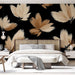 Une chambre moderne avec un papier peint floral aux grandes feuilles beige sur fond noir, créant une ambiance élégante et chaleureuse.