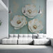 Un salon moderne avec un papier peint floral aux grandes fleurs blanches et dorées sur fond bleu apaisant, créant une atmosphère élégante et sereine.