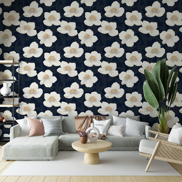 Un salon moderne avec un papier peint floral sur fond bleu marine, mettant en valeur de grandes fleurs blanches et des touches dorées, créant une atmosphère élégante et apaisante.