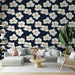 Un salon moderne avec un papier peint floral sur fond bleu marine, mettant en valeur de grandes fleurs blanches et des touches dorées, créant une atmosphère élégante et apaisante.