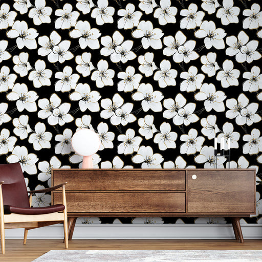 Un salon élégant avec un papier peint floral noir orné de grandes fleurs blanches, créant une ambiance chic et contemporaine.