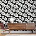 Un salon élégant avec un papier peint floral noir orné de grandes fleurs blanches, créant une ambiance chic et contemporaine.