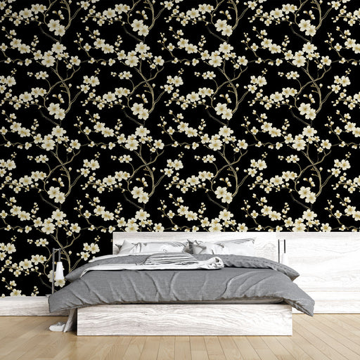 Une chambre moderne avec un papier peint floral représentant des branches délicates de fleurs blanches sur fond noir, créant une ambiance élégante et apaisante.