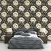 Une chambre élégante avec un papier peint floral aux grandes fleurs blanches et dorées sur fond noir, créant une atmosphère à la fois chic et apaisante.