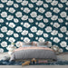 Une chambre moderne avec un papier peint floral blanc sur fond bleu profond, créant une atmosphère élégante et apaisante.