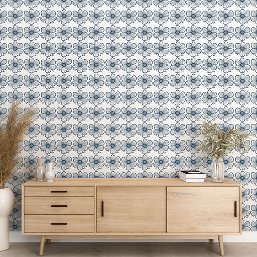 Une pièce moderne avec un papier peint floral bleu marine sur fond blanc, créant une ambiance fraîche et élégante.