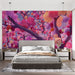 Une chambre moderne avec un papier peint floral vibrant aux motifs de fleurs roses et violettes sur fond mauve, créant une atmosphère chaleureuse et artistique.