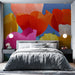 Une chambre moderne avec un papier peint floral éclatant aux grandes fleurs colorées sur fond bleu, créant une atmosphère joyeuse et vivifiante.