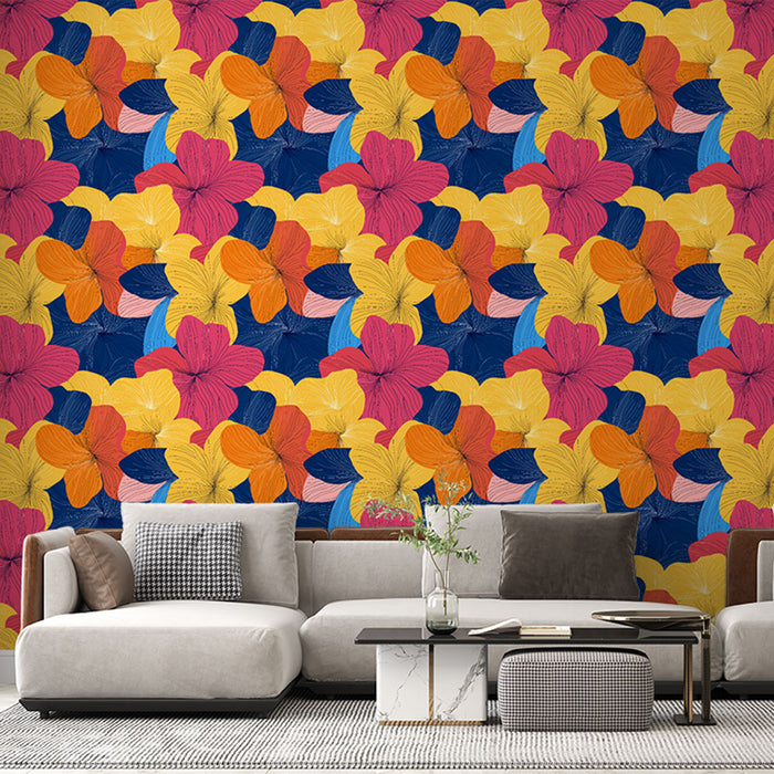 Un salon moderne avec un papier peint floral coloré aux motifs de grandes fleurs roses, jaunes et oranges sur fond bleu, créant une ambiance joyeuse et dynamique.
