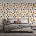 Une chambre moderne avec un papier peint floral aux motifs colorés de fleurs roses, jaunes et bleues sur fond clair, créant une atmosphère joyeuse et accueillante.