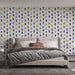 Une chambre moderne avec un papier peint floral aux motifs colorés de fleurs violettes, jaunes et bleues sur fond clair, créant une ambiance joyeuse et accueillante.