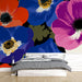 Une chambre moderne avec un papier peint floral aux grandes fleurs colorées, mêlant rouge, bleu et rose, créant une ambiance vibrante et joyeuse.