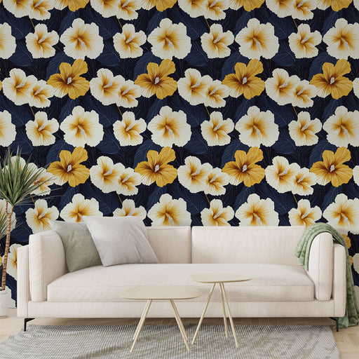 Un salon moderne avec un papier peint floral aux grandes fleurs jaunes et blanches sur fond bleu marine, créant une ambiance tropicale et chaleureuse.