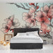 Une chambre élégante avec un papier peint floral aux grandes fleurs roses et blanches, créant une atmosphère douce et romantique.