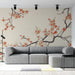 Un salon contemporain avec un papier peint floral représentant des branches de cerisier en fleurs aux teintes douces et apaisantes sur fond beige.