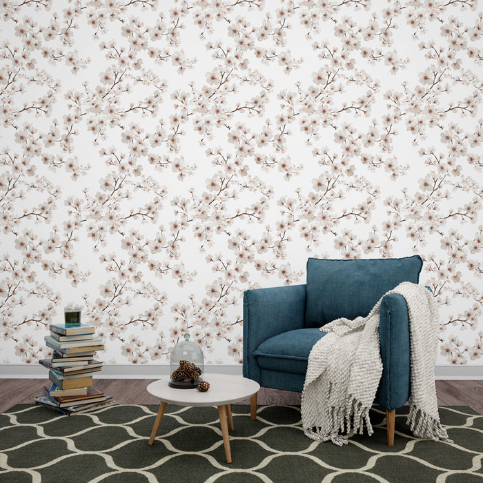Une chambre accueillante avec un papier peint floral aux motifs de branches délicates et fleurs roses sur fond blanc, dégageant une atmosphère douce et apaisante.