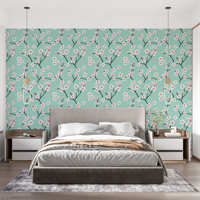 Une chambre moderne avec un papier peint floral vert menthe orné de délicates fleurs roses et de branches noires, créant une atmosphère fraîche et apaisante.