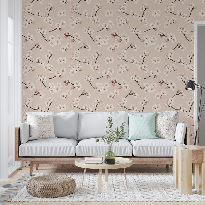 Un salon lumineux avec un papier peint floral sur fond beige, orné de branches de cerisier et de fleurs roses, créant une ambiance douce et apaisante.
