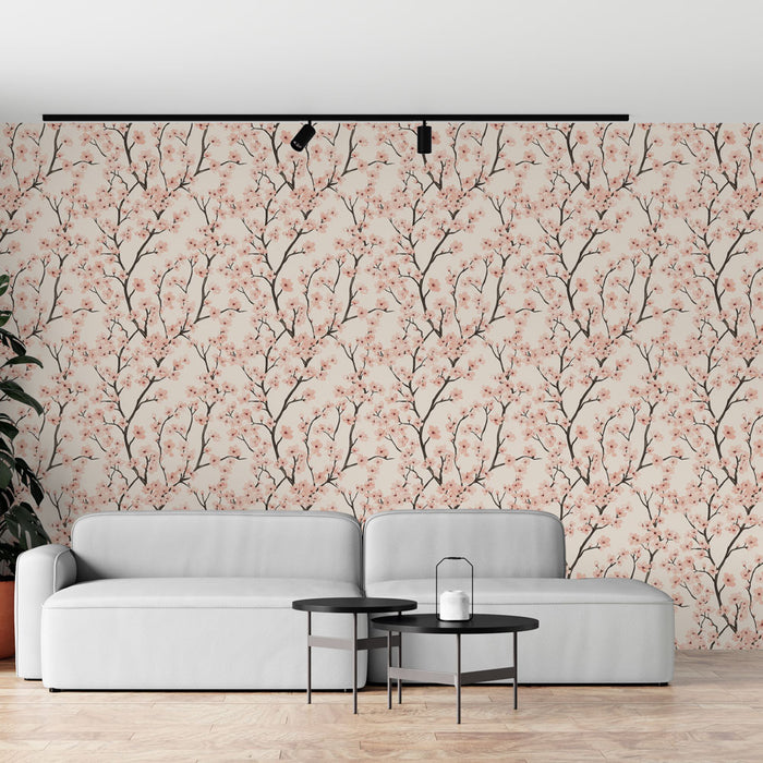Un salon moderne avec un papier peint floral aux motifs de branches délicates et de fleurs roses sur un fond beige, créant une ambiance douce et apaisante.