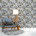 Une pièce moderne avec un papier peint floral aux motifs de fleurs blanches et branches noires, rehaussé de touches dorées, créant une ambiance élégante et apaisante.